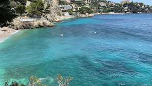 Une zone côtière caractérisée par des eaux turquoise et limpides, des falaises rocheuses et des bâtiments construits sur le flanc de la colline.