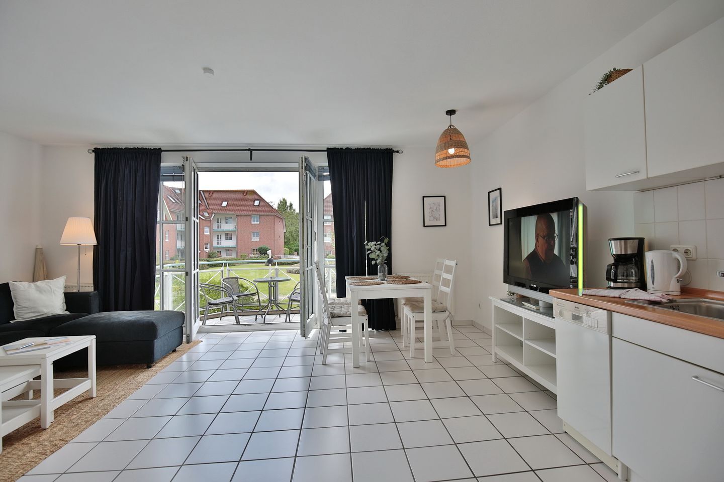 A modern apartment with a balcony, a dining area, a living room, and a kitchen.