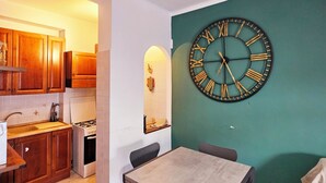 Una cocina compacta con gabinetes de madera, una estufa a gas y un comedor con mesa y sillas.