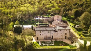 An aerial view of a historic stone building with a courtyard, surrounded by lush greenery. - Apartment with hot tub, A/C, WIFI, sauna, private pool, TV, patio, panoramic view, close to Siena (Monteriggioni)