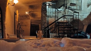 A hot spring area with a stone wall and a staircase leading to an upper level. - Deep Cave House  (Urgup)