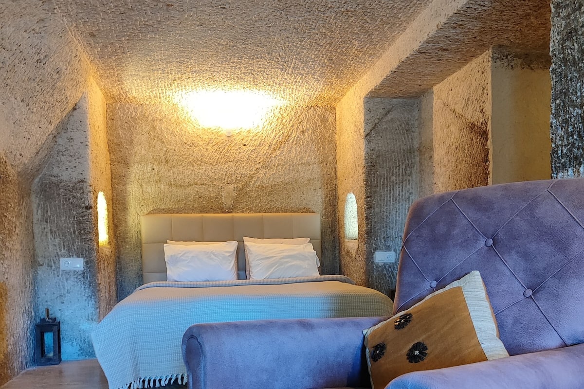 Ein Zimmer mit einem Bett, einem Sessel und einer strukturierten Decke.