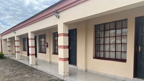 A building with a tiled walkway and a covered entrance area. - Kalimba Guesthouse (Gaborone)
