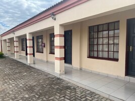 Un edificio con pasarela adoquinada y zona de acceso cubierta.