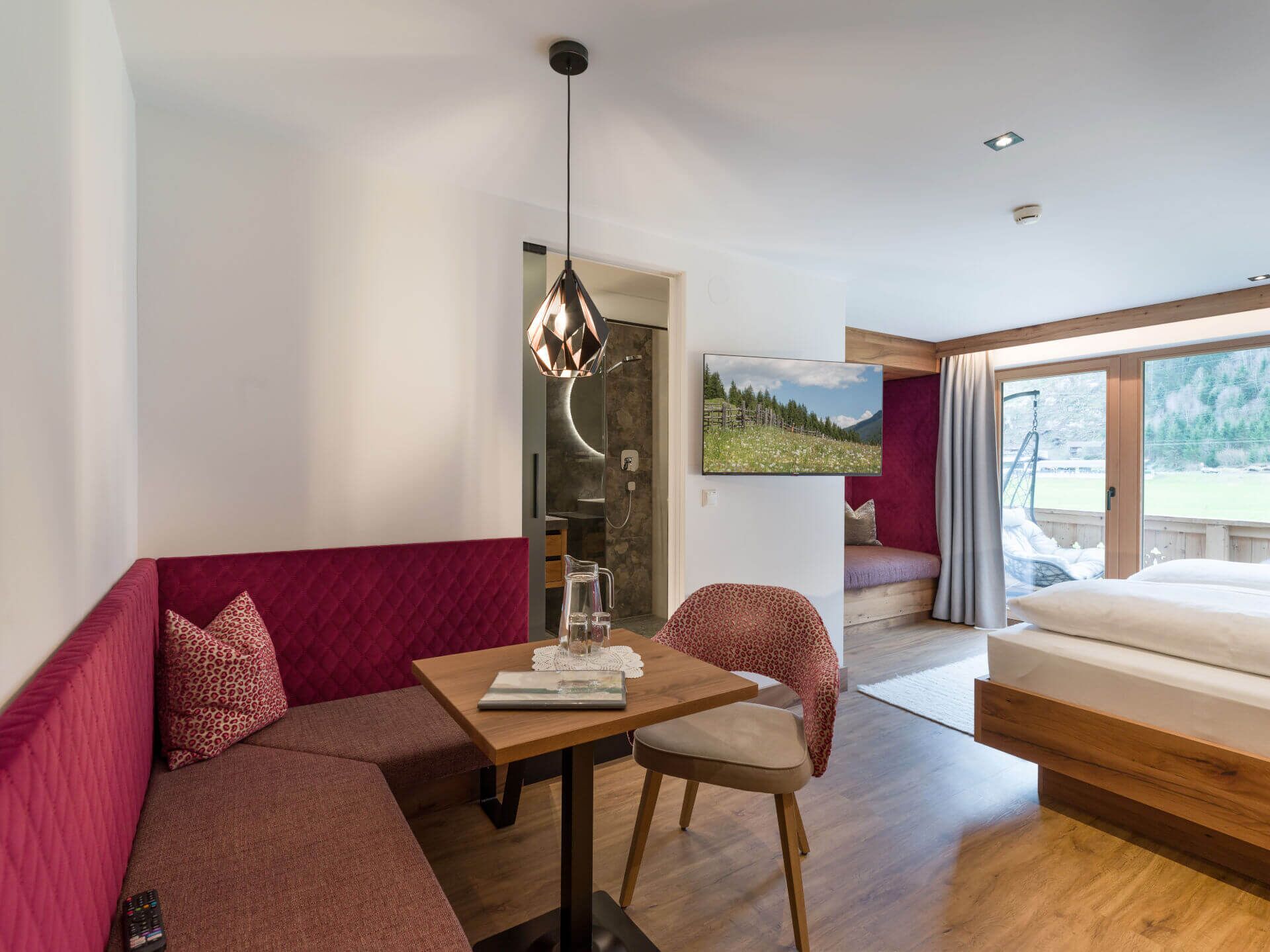 Una habitación moderna con una mesa de madera, un sofá, una silla y una cama.