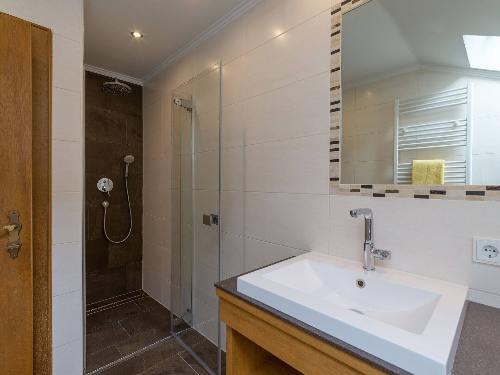 A modern bathroom with a shower, a sink, and a mirror.