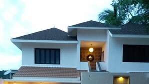 A modern two-story house with a tiled roof, a covered porch, and a landscaped front yard with a pathway. - Mount Retreat (Madurai)