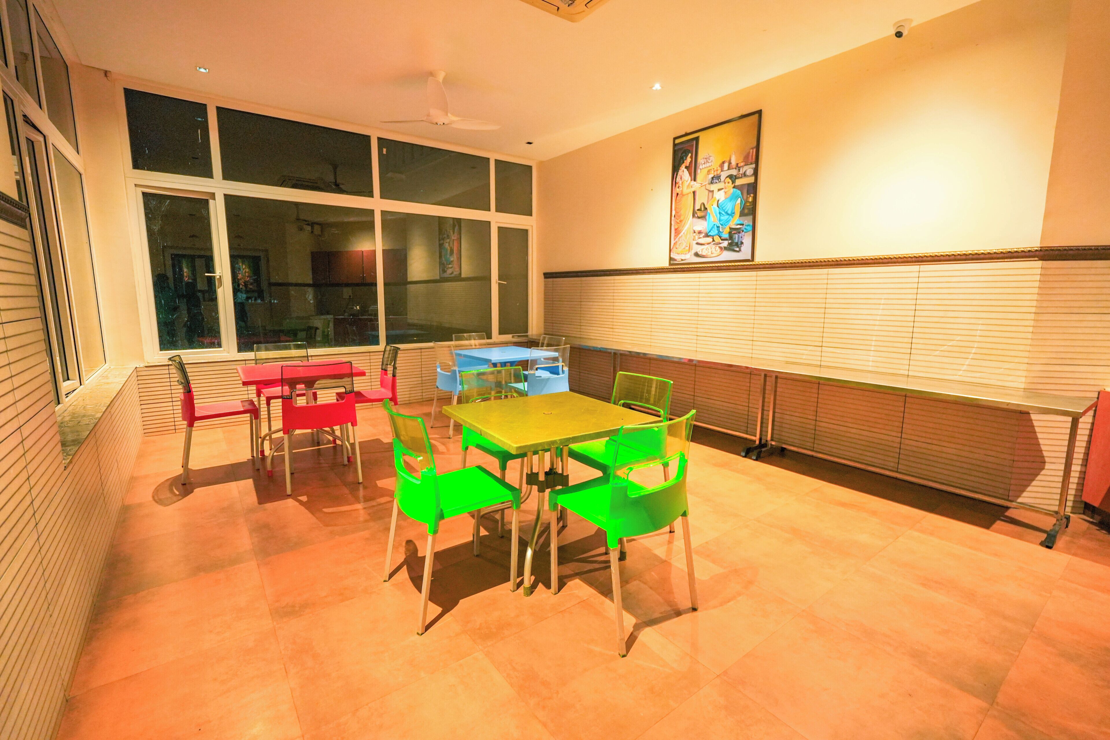 A dining area with a table and chairs, large windows, and a ceiling fan.