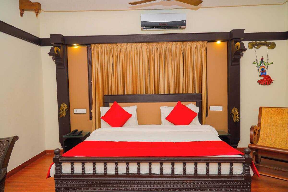 Une chambre d’hôtel avec un grand lit, un ventilateur de plafond, un appareil de climatisation et un élément décoratif mural.