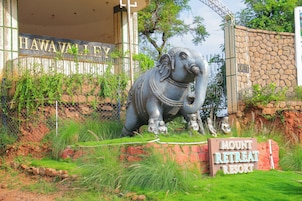 Une statue d’éléphant se trouve devant un bâtiment portant l’inscription « HAWALLEY », et un panneau indique « MOUNT RETREAT RESORT ».