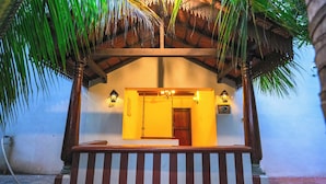 A building entrance with a wooden porch, a door, and two wall-mounted lights. - Mount Retreat (Madurai)
