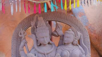 A detailed stone sculpture of deities with intricate carvings and a decorative arch.