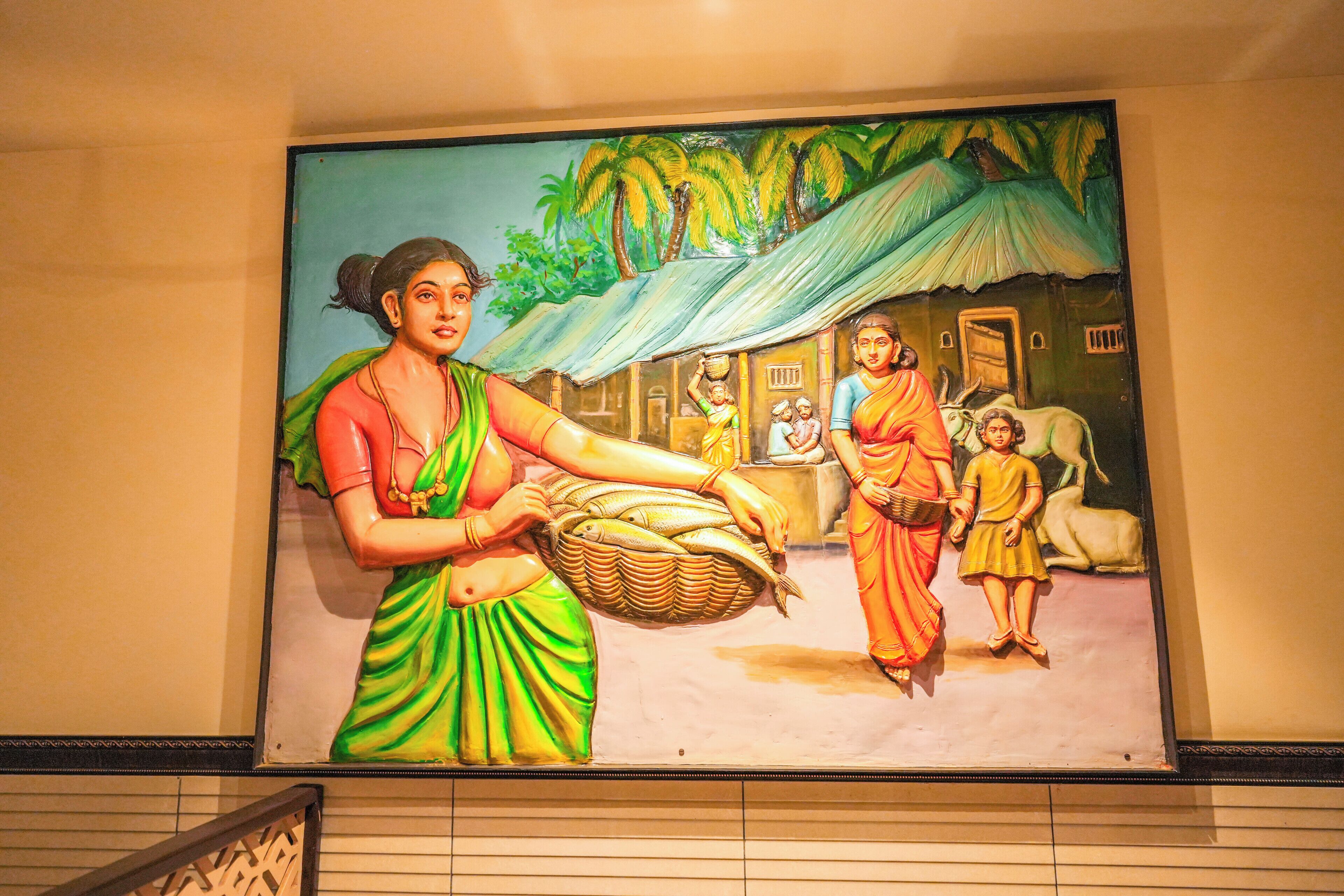 A mural with a woman carrying a basket, a child, and a man in traditional attire.