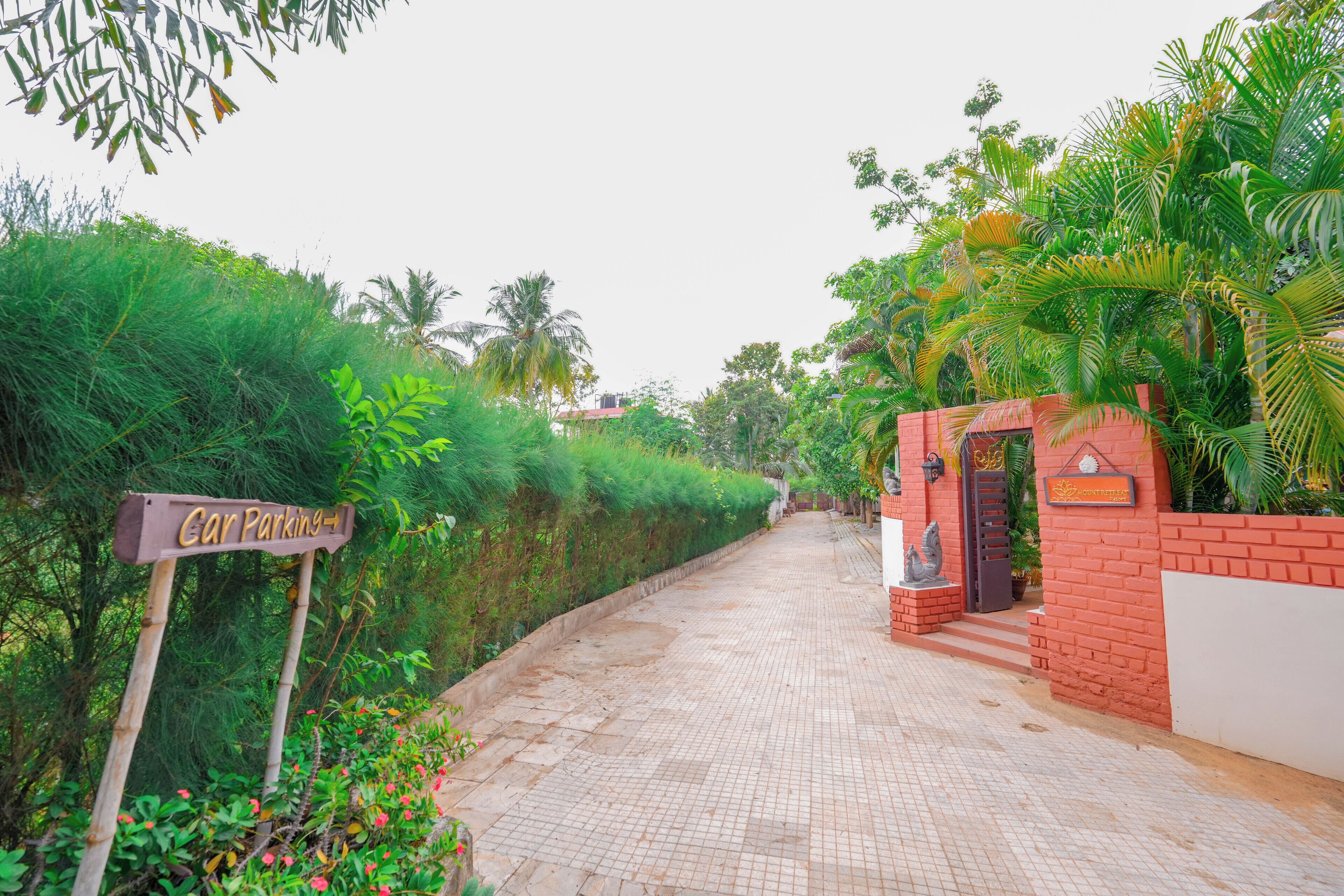 A paved pathway leading to a gated entrance with a sign indicating 'Car Parking'.