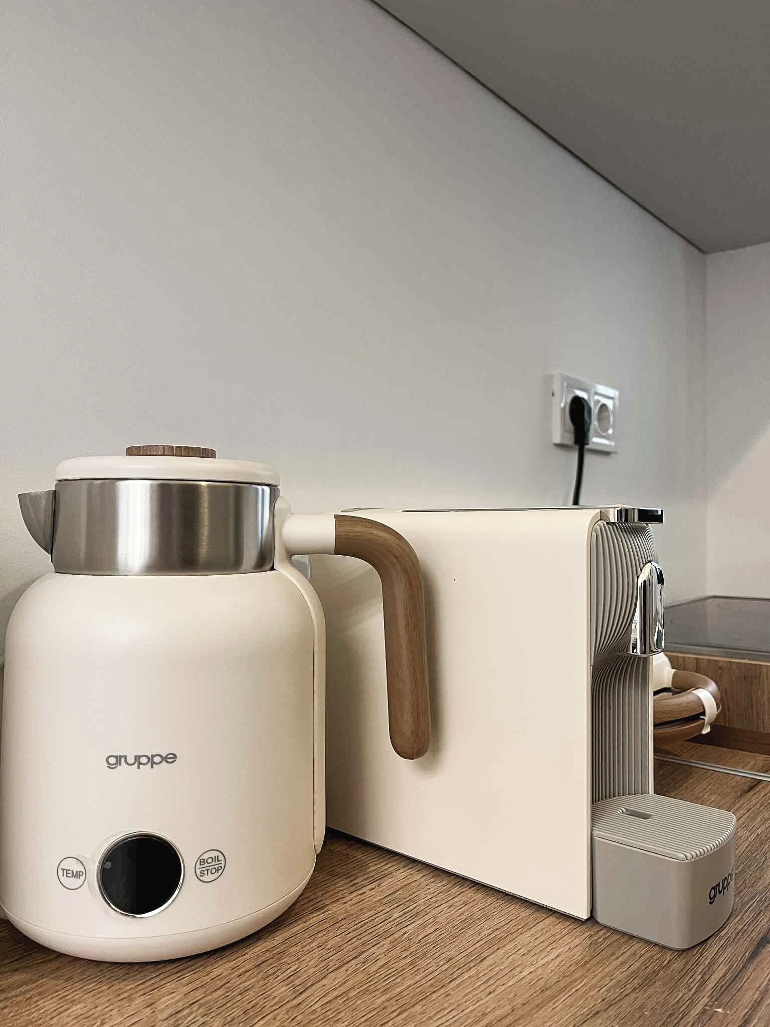 Una cocina moderna con un electrodoméstico blanco, un pomo de madera y un panel de control con botones etiquetados como 'TEMP' y 'BOIL STOP'.