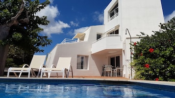 Una piscina al aire libre, tumbonas