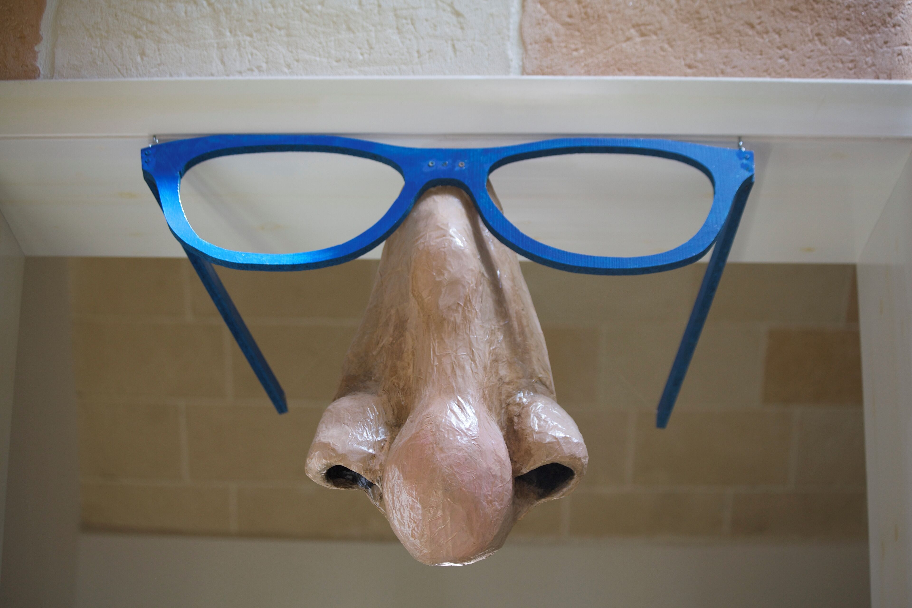 Een houten object met blauwe randen dat aan een plafond hangt.