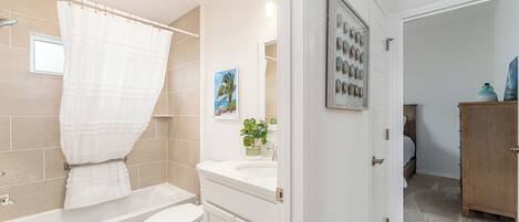 Een moderne badkamer met een bad, toilet en wastafel.