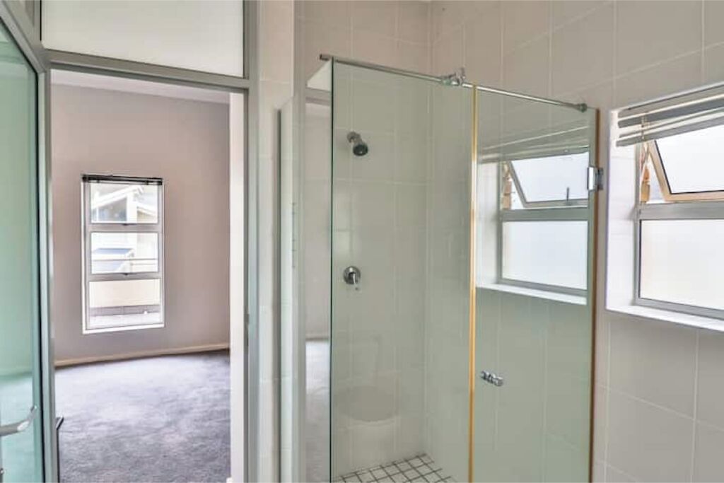 A glass-enclosed shower with a door, a window, and a towel rack.