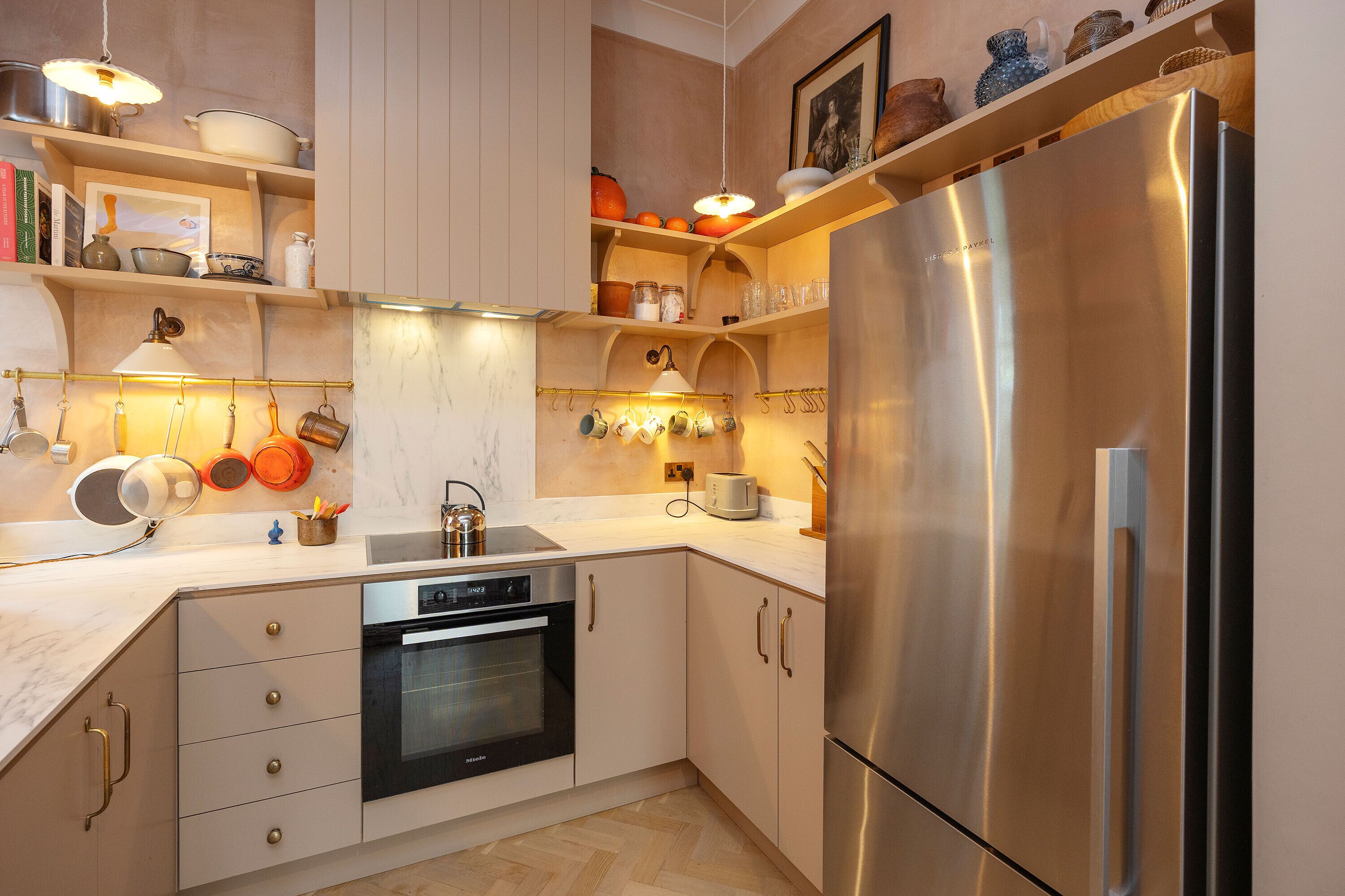 Een moderne keuken met roestvrijstalen apparatuur, houten kastjes en een marmeren aanrecht.