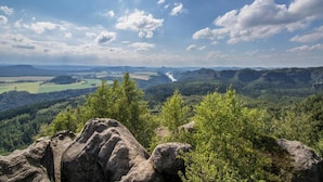 Een weids uitzicht over een berglandschap met rotsformaties en dicht bos.