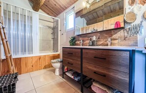 A bathroom with a wooden vanity, a shower, and a toilet. - Awesome home in Arles (Arles)