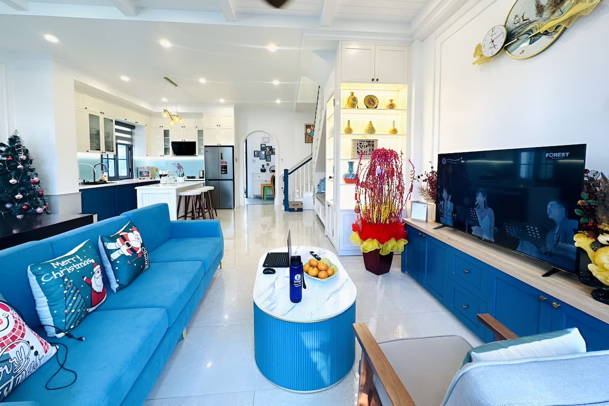 A modern living room with a blue sofa, a coffee table, and a TV.