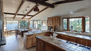 Una cocina amplia con armarios de madera, una isla grande y vista a un lago.