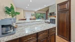 Una cocina con encimeras de granito, armarios de madera y estufa integrada.
