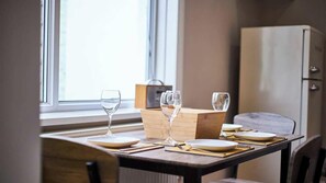 A dining table set with plates, cutlery, and wine glasses, with a wooden box and a cabinet in the background. - Vacant Nests | The Park View | Seaham Hideaway (County Durham)