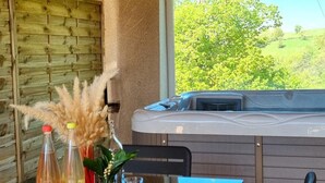 A room with a wooden wall, a hot tub, and a table with bottles and glasses. - Spacious cottage for 12 with private garden and spa in Chevrières (Chevrières - Loire)