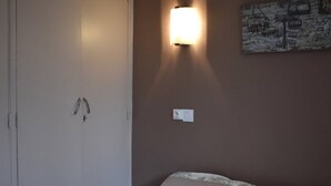 A bedroom with a bed, a wall-mounted light, and a painting. - Bright 3-room apartment - Pyrenees view and parking (Font-Romeu-Odeillo-Via)
