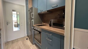 A compact kitchen with a built-in oven, a microwave, and a toaster oven.