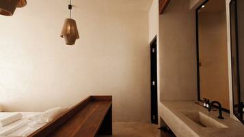 Un baño minimalista con un banco de madera, un espejo grande y un lavamanos.