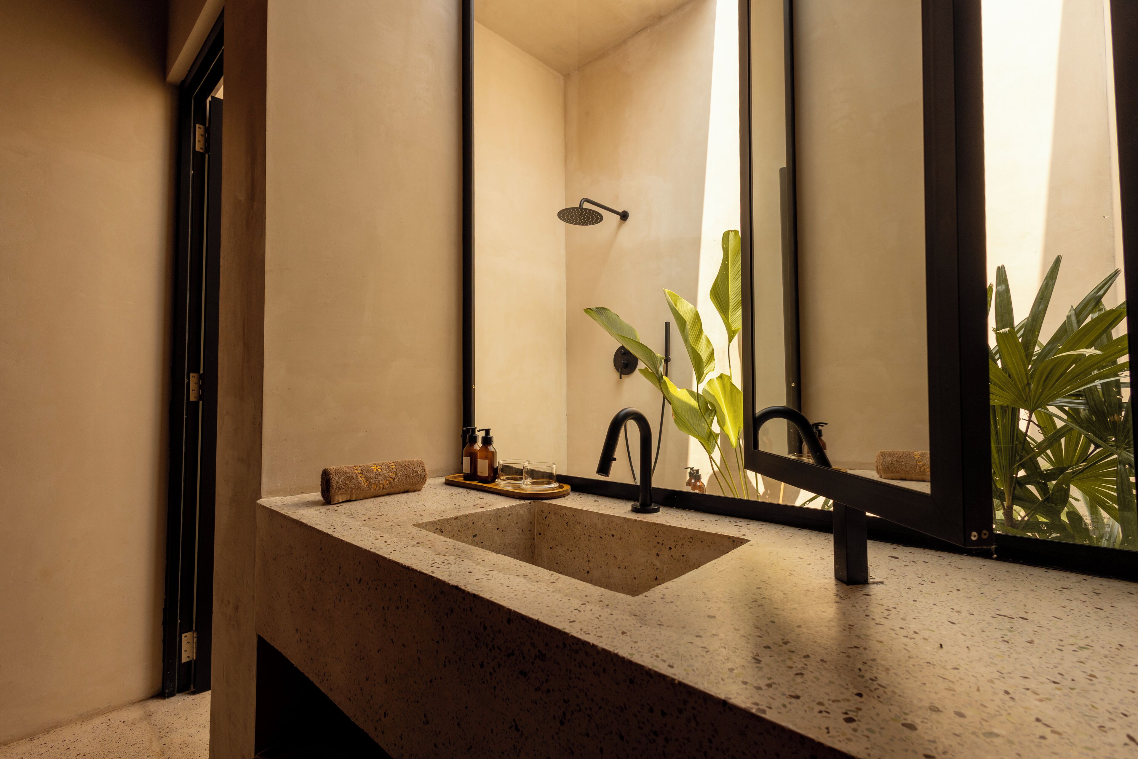 A bathroom with a large sink, a mirror, and a shower.