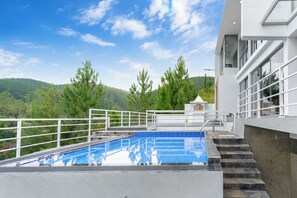 Una piscina en la azotea con vistas a un páramo boscoso.