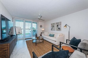 A modern living room with a sofa, coffee table, and artwork on the walls.