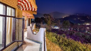 Un balcon offrant une vue sur un paysage montagneux la nuit.