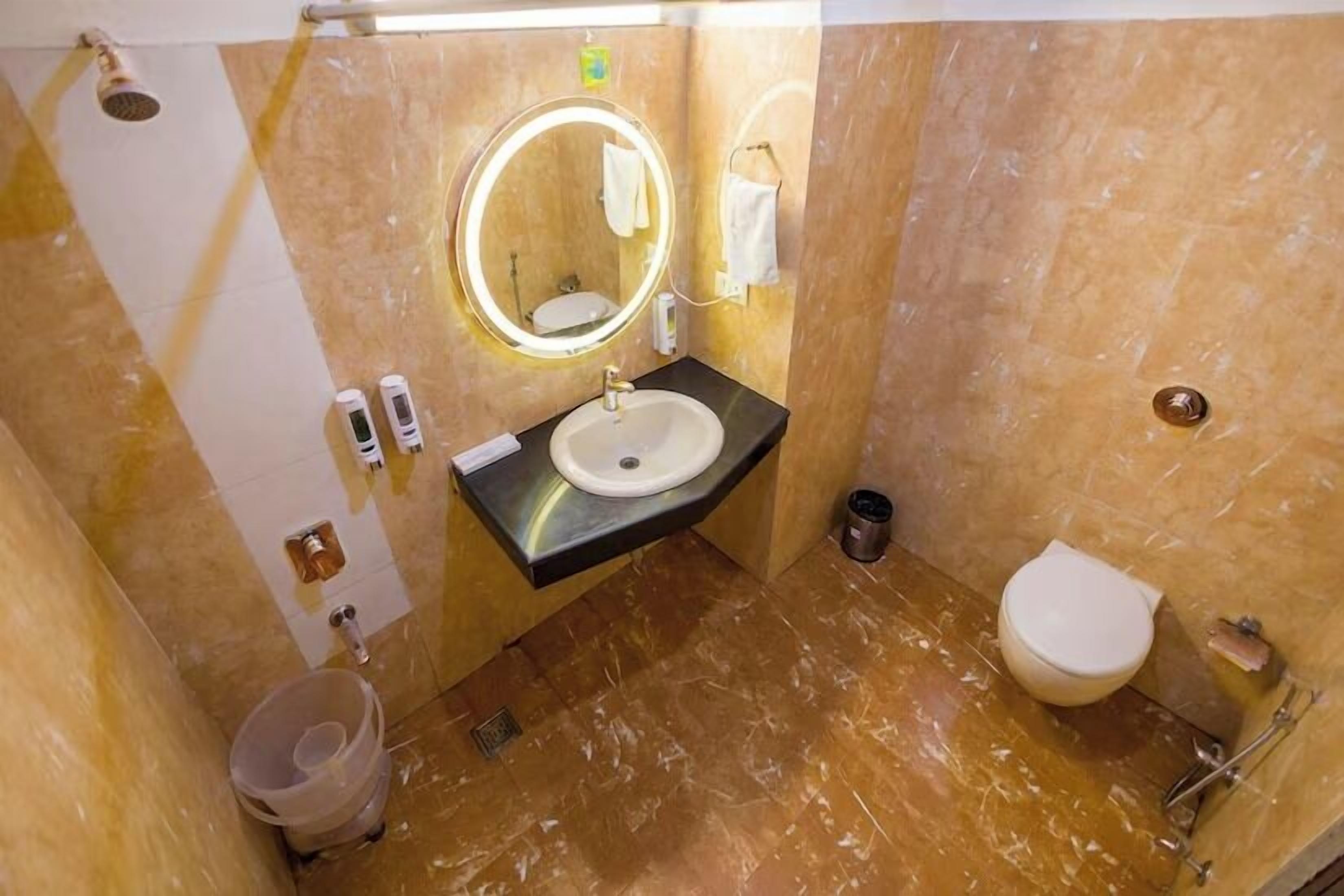 A bathroom with a sink, mirror, toilet, and shower.