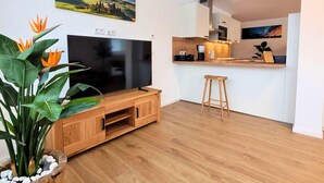 Ein modernes Wohnzimmer mit einer Holzunterhaltungsecke, einem Flachbildfernseher und einer Pflanze.
