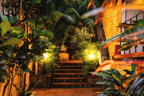 A staircase surrounded by lush greenery and illuminated by warm lights, leading to a higher level. - Palm Beach Lifestyle Resort By Anusaksh (Agonda)