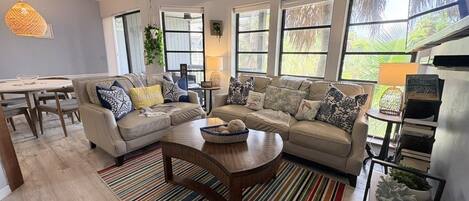 A living room with a sofa set, a coffee table, and a striped rug.