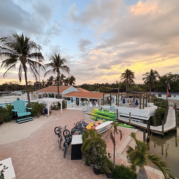 A resort with a pool, outdoor seating, and a covered area.