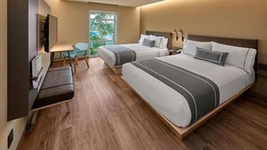 Habitación de hotel moderna con dos camas, un escritorio, un televisor y vistas al exterior.
