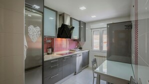 Een moderne keuken met roestvrijstalen apparatuur, een betegelde spatwand en een raam dat voor daglicht zorgt.