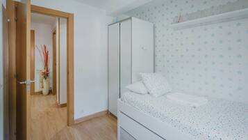 Ein Schlafzimmer mit Bett, Kleiderschrank und einer Tür zu einem anderen Raum.