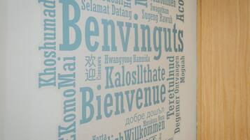 A wall with various words in different languages, likely indicating multilingual signage or a welcome message.