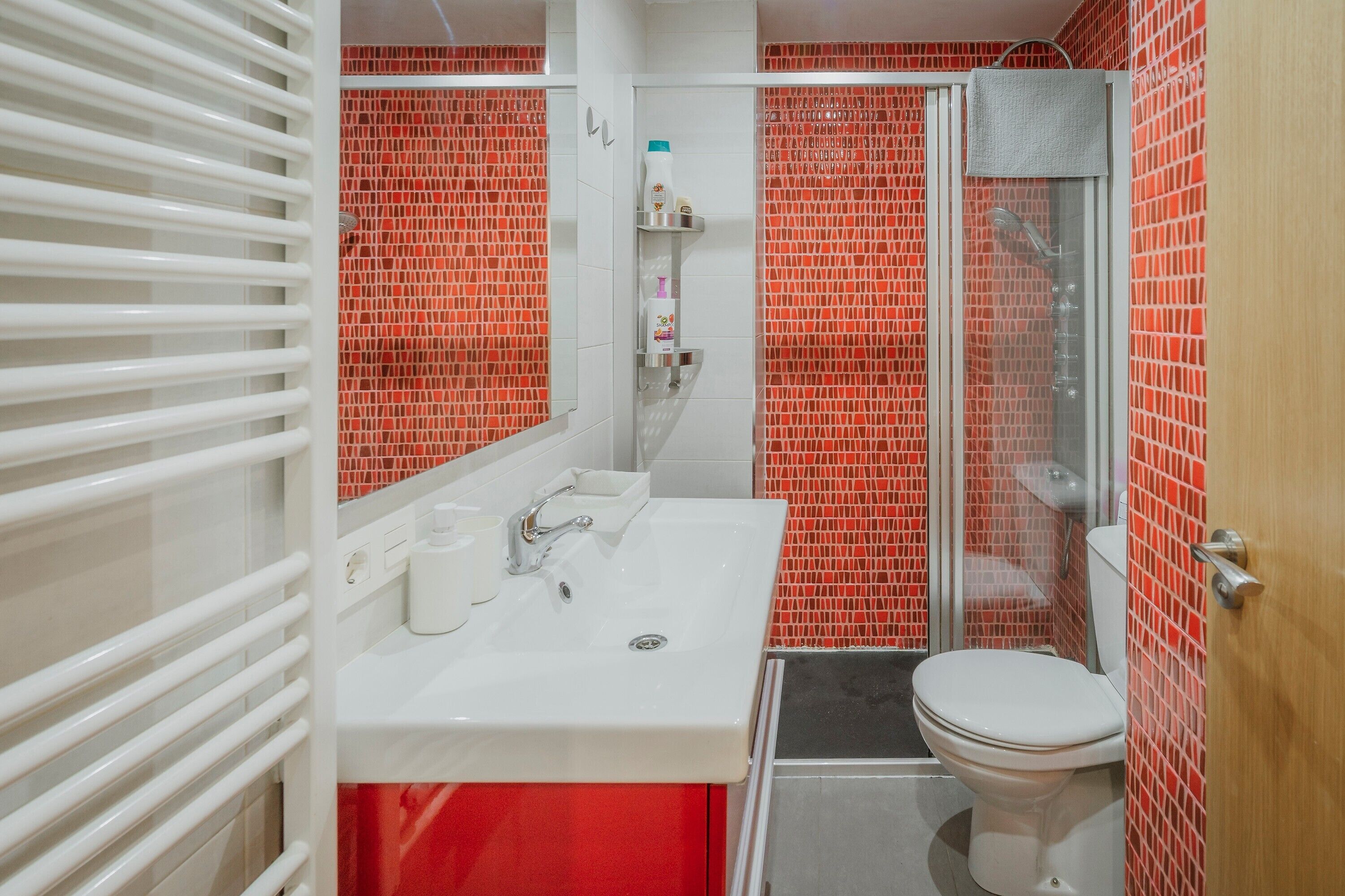 Een badkamer met een wit wastafel, toilet en douche.