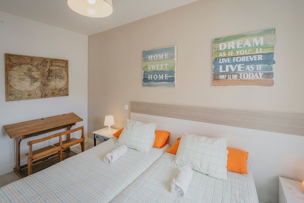 Une chambre d’hôtel avec un lit, des oreillers, un bureau et des œuvres d’art murales.