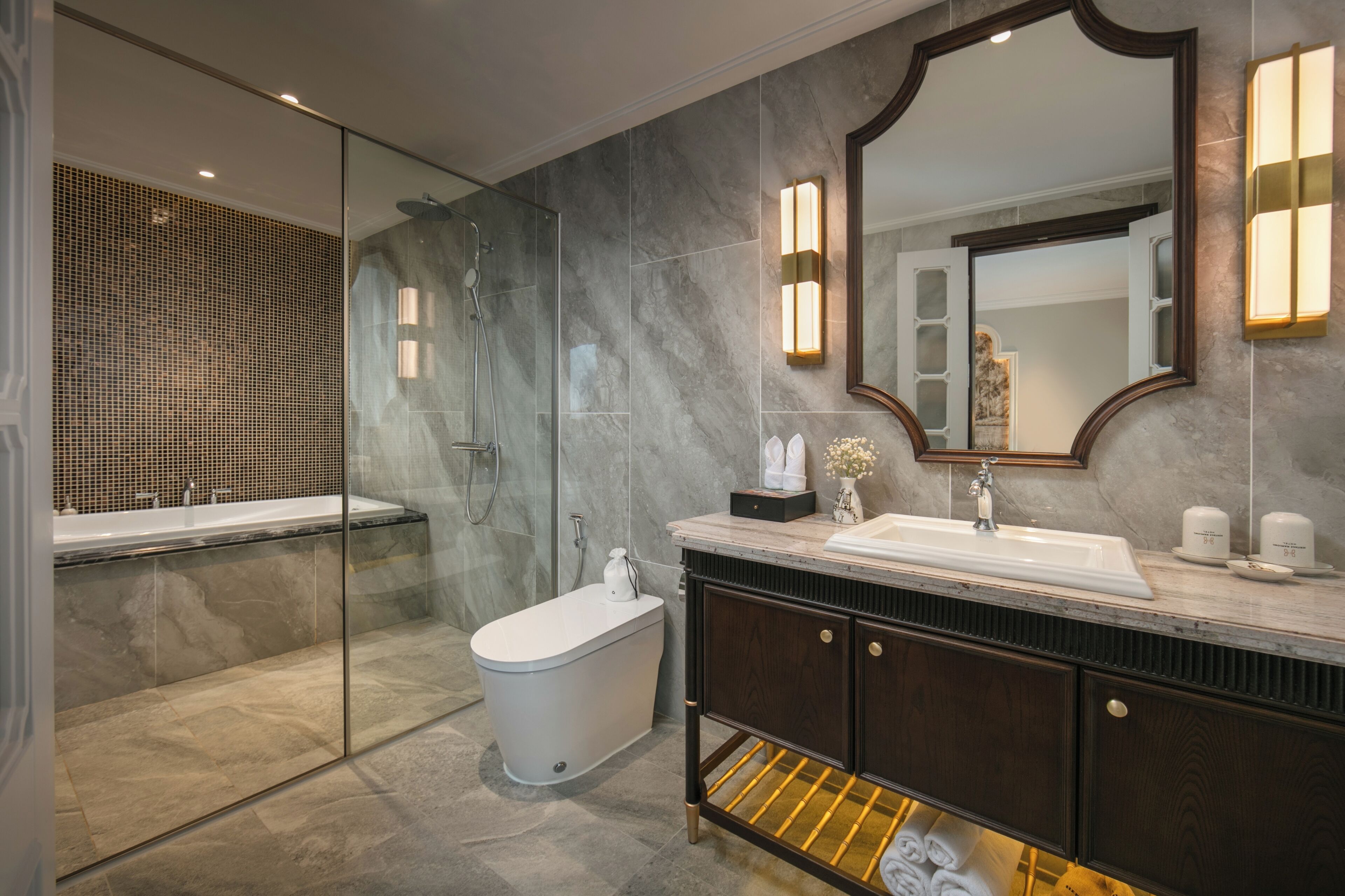 A modern bathroom with a glass-enclosed shower, a freestanding bathtub, a vanity with a sink, and a large mirror.